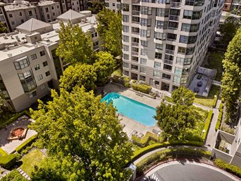 an aerial view of a swimming pool in front of an apartment building